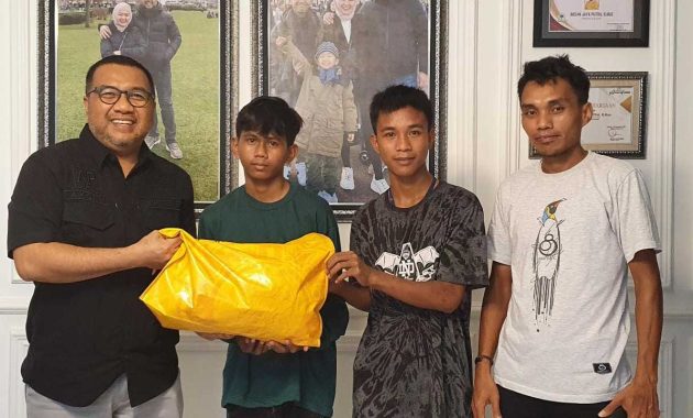 Wakil Ketua Komisi III DPRD Provinsi Sulawesi Tenggara (Sultra) Aksan Jaya Putra (pertama dari kiri) menyerahkan bantuan kepada dua anak kurang mampu di Kendari untuk kembali bersekolah melalui program AJP Peduli, Selasa (18/1/2022). Foto/ist