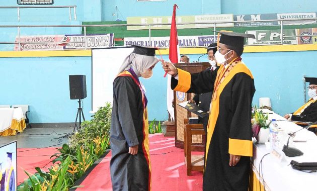 Rektor Universitas Halu Oleo (UHO) Kendari, Prof. Muhammad Zamrun Firihu memindahkan tali toga salah satu wisudawan terbaik pada acara wisuda UHO periode Oktober 2021 – Januari 2022 pada Senin (3/1/2022) di Sport Center UHO. Foto/ist