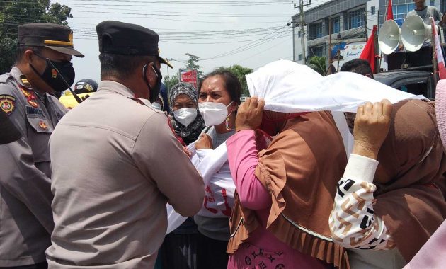 Puluhan emak-emak melakukan aksi demo di depan Markas Kepolisian Daerah (Polda) Sulawesi Tenggara (Sultra), Senin (31/1/2022). Foto/herlis