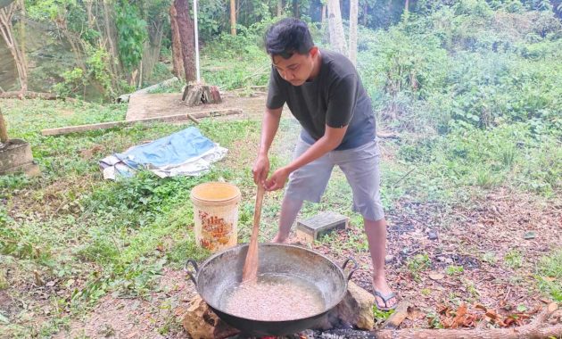 Seorang pria di Kota Kendari, bernama Rian Adriansyah (32) saat mrmbuat minyak goreng sendiri dari buah kelapa, Sabtu (12/3/2022). Foto/ist
