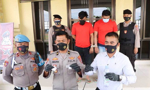 Kepala Bagian Operasional Kepolisian Resort Kota (Polresta) Kendari, Komisaris Polisi Jupen Simanjuntak (baju coklat) didampingi Kepala Satuan Narkoba Polresta Kendari, Ajun Komisaris Polisi Hamka (baju putih) saat menunjukan barang bukti sabu dari kedua tersangka HN dan SS. Foto/ist