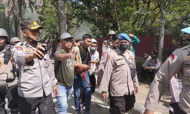 Polisi saat mengamankan seorang mahasiswa yang dicurigai menjadi  provokasi terjadinya ricuh demo di Kantor DPRD Sultra, Senin (11/4/2022). Foto/R. Hafid/bentaratimur.id