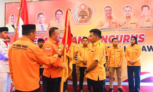 Ketua Dewan Pimpinan Daerah Organisasi Masyarakat (Ormas) Musyawarah Kekeluargaan Gotong Royong (MKGR) Sulawesi Tenggara, Aksan Jaya Putra menyerahkan pataka MKGR kepada Ketua DPC MKGR Kabupaten Konawe, Wahyu Rahmadi, usai dilakukan pelantikan di salah satu hotel di Kota Kendari, Jumat (30/9/2022). Foto/R. Hafid/bentaratimur.id