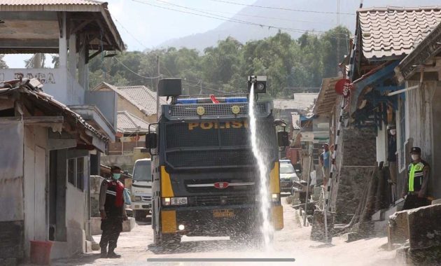 Personel Polresta Magelang membantu membersihkan jalan dampak abu vulkanik pasca adanya erupsi Merapi di Kabupaten Magelang, Jawa Tengah, Minggu (12/3/2023). Foto/ist