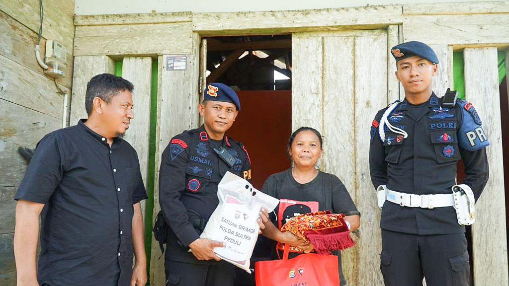 Personel Brimob Polda Sulawesi Tenggara (Sultra) menyalurkan bantuan paket sembako kepada warga di RT 08 Desa Langgea, Kecamatan Ranomeeto, Kabupaten Konawe Selatan, Sabtu (3/6/2023). Foto/ist