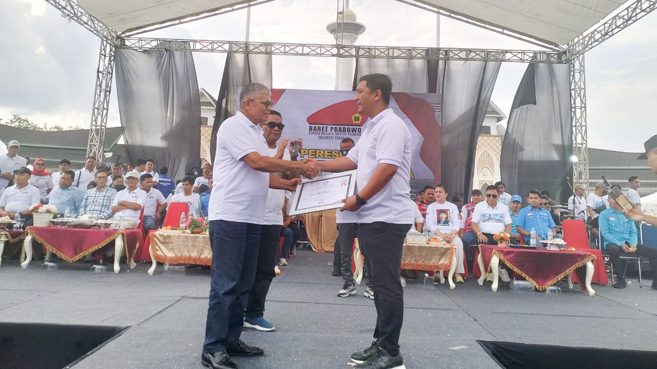 Wakil Ketua Umum Dewan Pimpinan Pusat (DPP) Partai Gerindra, Mayjen TNI (Purn) Musa Bangun (kiri) menyerahkan piagam kepada Ketua Barisan Relawan Tangguh (Baret) Prabowo Sulawesi Tenggara (Sultra), Triawan Rizbar Taha sebagai tanda dikukuhkannya pengurus Baret Prabowo Sultra, di pelataran Eks MTQ Kendari, Sabtu (18/11/2023). Foto/R. Hafid/bentaratimur.id