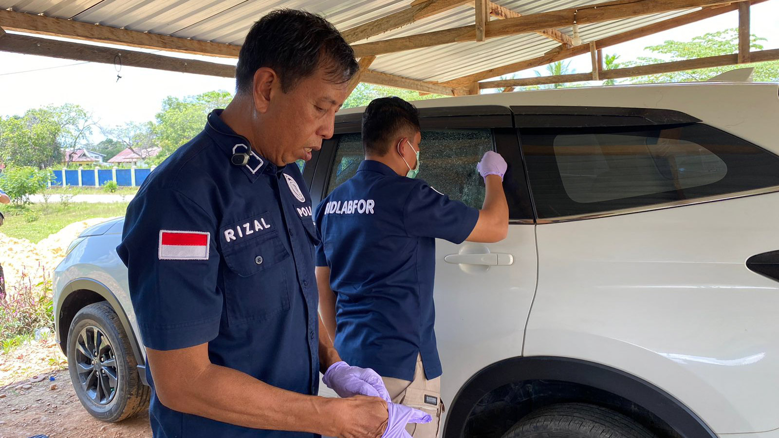 Tim Opsnal Resmob dari Unit IV Dit Reskrimum Polda Sulawesi Tenggara bersama dengan Bidang Laboratorium Forensik (Labfor) Polda Sulawesi Selatan melakukan pengecekan dan pemeriksaan fisik kendaraan dinas Camat Baito yang mengalami keretakan pada kaca tengah bagian kiri yang diduga kena tembakan, Selasa (29/10/2024). Foto/ist