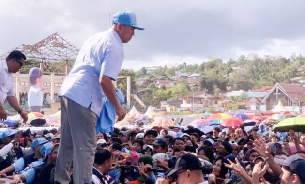 Calon Gubernur Sulawesi Tenggara (Sultra), Andi Sumangerukka saat membagi-bagikan kaos kepada warga yang menghadiri kampanye akbarnya bertajuk 'Pesta Rakyat Berkah'di Lapangan Benu-Benua, Kota Kendari, Sabtu (9/11/2024). Foto/R. Hafid/bentaratimur.id